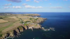 Aerial shot tracking from ocean to the Cliffs and rocky coastline of Lizard Point in Cornwall UK