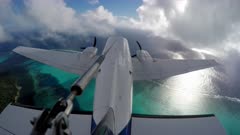 Twin Engined aircraft flies over Reef and Ocean and through layers of cloud. External mounted action cam.