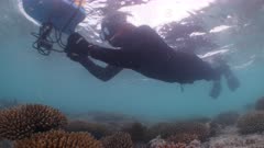 Underwater shot of marine scientist mapping coral reef colonies with GPS camera