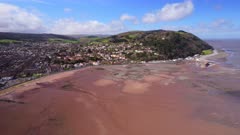 High Wide Aerial shot of Minehead seafront, headland and shoreline at very low tide. Somerset, UK