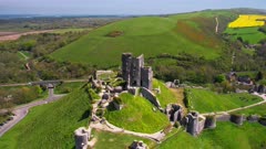 Aerial shot orbiting Castle ruins with Corfe village in background, in Dorset England
