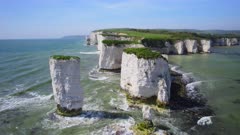 Ascending Aerial shot of chalk stacks and white cliff coastline. Old Harry Rocks, Dorset, UK