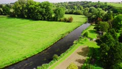 Aerial shot tracking along the River Avon as it flows through the countryside in Wiltshire, UK