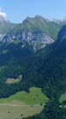 Vertical drone footage of the Annecy lake and the beautiful mountains around it. The camera is doing a full 360 degrees panning showing the Annecy lake surrounded with rocky peak mountains.