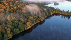 sunrise aerial hyperlapse of morning mist above lake &amp; full autumn colors coniferous forest (4K, UHD, hyperlapse)