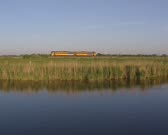 Diesel Train of Dutch Railways NS in Dutch countryside. FRIESLAND, THE NETHERLANDS - 1990s