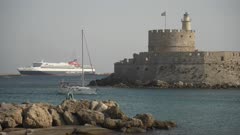 Sailboat passing Saint Nicholas Fortress in Mandraki Marina and Port, Rhodes Town, Rhodes, Dodecanese Islands, Greek Islands, Greece, Europe