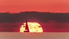 Time lapse of a sail boat sailing in front of the sun at sunrise, Cullera, Valencian Community, Spain, Mediterranean, Europe