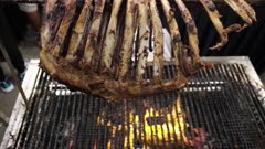 The roasted mutton lamb skeleton Kambing Golek on the burn charcoal. Delicious Malaysia street food