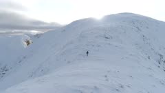 Mountain Climber Walking Along a Snowy Ridge
