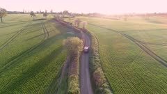 Aerial View of a Luxury SUV Driving Through a Country Lane in the Evening