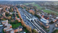 Commuter Train Approaching a Station in the UK Aerial View