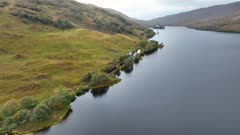 Steam Train in Scotland Passing By a Loch on the Famous Route