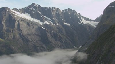 View of snowy mountains, pan left to cloud covered mountains