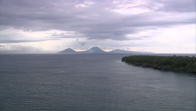 View of coast and mountain and volcano silhouettes in distance