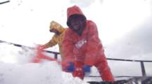 crab Fishing Bering Sea - Fishermen work hard beating ice from boat in rough sea, dark inky water, waves