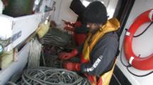 men attach bait to hooks, longlining for halibut and black cod alaska