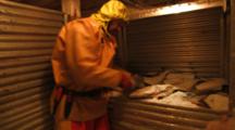 Man On Fishing Boat Handles Halibut Catch In Icy Hold, Longlining For Halibut And Black Cod Alaska