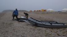 Pan From Waves To People Setting Up Inflatable Boat