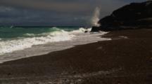 Waves Wash Up On Dark Sand Beach
