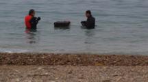 Men In Shallow Water Work With Electronic Instrument