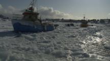 View From Boat Traveling Through Melt Ice From Village, Past Boats Stuck In Ice