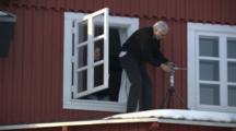 Man On Roof Adjusts Instrument