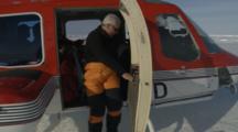 Pan To Person Disembarking From Helicopter On Ice Field