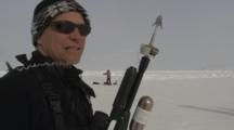 Man Near Helicopter On Ice Field Carrying Tagging Gun ?