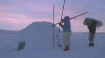 Inuit People Carry Equipment Away From Igloo