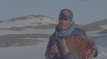 Inuit Man Plays Accordion, Arctic Landscape Behind