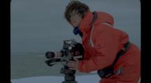Film Maker In Survival Suit Uses Tripod On Ice