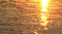 Sunset Reflected On Sand And Gentle Waves