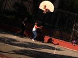 Two Men Play Basketball In Poor Neighborhood