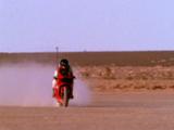 Man Rides Motorcycle In Desert