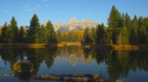 Teton Peaks And Fall Trees Reflected In Water At Schwabacher Landing