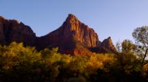 Steep Red Rock Formations Lit By Golden Sunlight