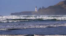 View Across Water To Yaquina Head Lighthouse On Rugged Coast Of Oregon