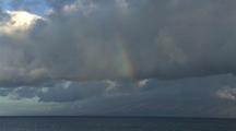 Rainbow And Dark Clouds Over Ocean