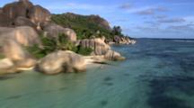 Aerial Along Coastline In Seychelles, Boulders, Reef Through Clear Water