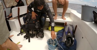 A Medium Shot of the Diver who saved the Entangled Manta. With the bucket full of thick white fishing line that was wrapped around the Manta.