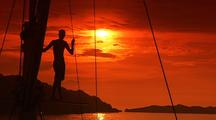 Person Silhouetted On Sailboat Mast At Sunset