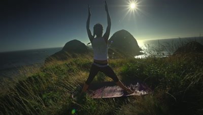 Woman practicing yoga on hill overlooking Pacific Ocean,Oregon