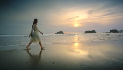 Young woman walking beach at sunset Port Orford OR