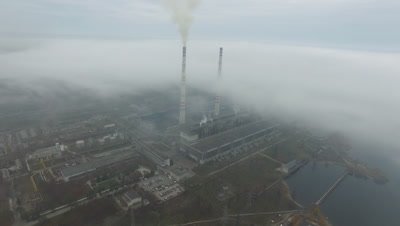 Aerial view of coal power station with smoke goes from tubes. Fog or clouds cover the land. View from the birdВ’s-eye view.