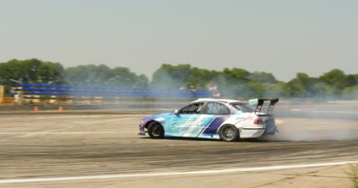 Participant in a drifting competition and burning tires on drag race track