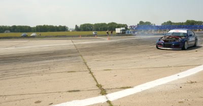 Participant in a drifting competition and burning tires on drag race track