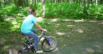 Cyclist riding the bike on the trail in the beautiful summer forest