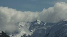 Storm Clouds Gather Over Snowy Peaks