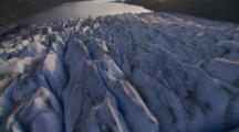 Aerial Cineflex Travel Over Craggy Glacier Spires Of Ice Toward Ocean At Face Of Glacier